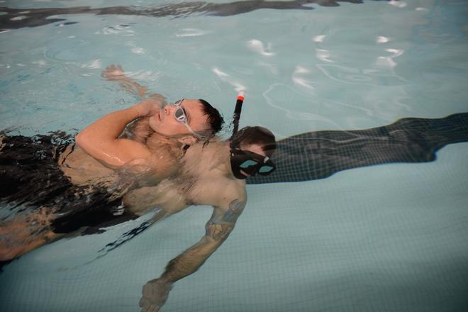 Petty Officer 2nd Class Paul Mills, an aviation survival technician, trains in the swimming pool at Massachusetts Maritime Academy on Cape Cod in Massachusetts on Jan. 19, 2017. This rescue technique is what rescue swimmers use when bringing survivors to the basket to be hoisted into the awaiting MH-60 Jayhawk helicopter to bring them home safely. - U.S. Coast Guard © Petty Officer 3rd Class Nicole Groll